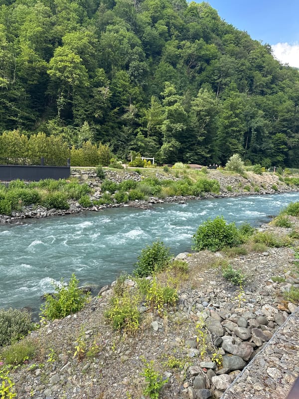 Turquoise river and mountain town, likely Russian Caucasus region