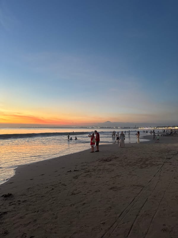 Two beachgoers with net observed during Kuta Selatan sunset