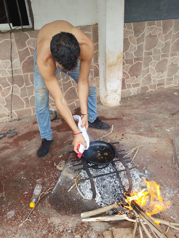 Man cooks outdoors with cast iron skillet in Tinaquillo
