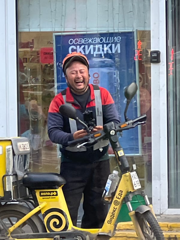Electric scooter delivery rider paused on a Moscow street