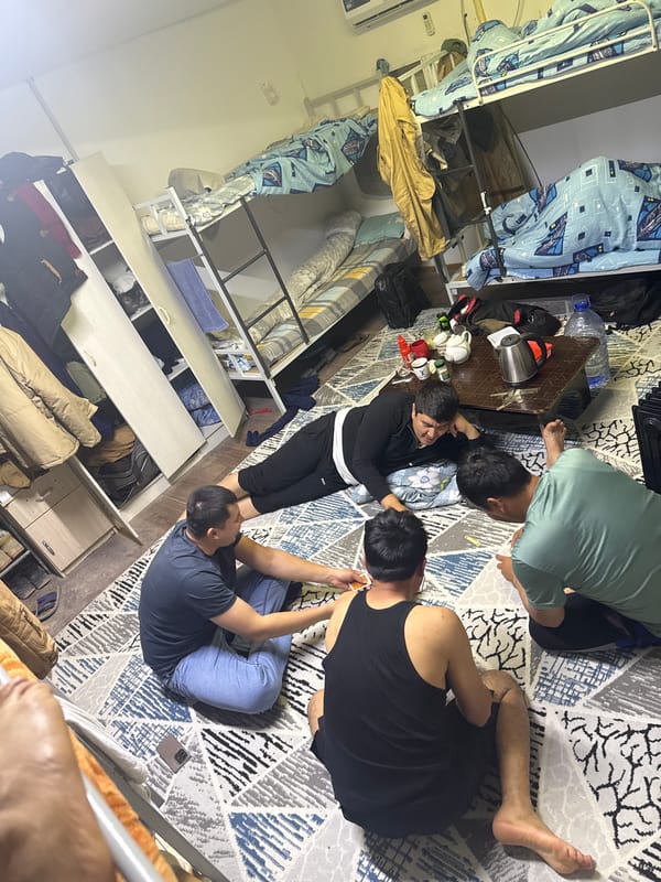Four people gather around table in Almalyk dormitory