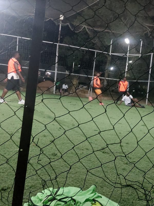 Nighttime soccer match captured on artificial turf in Nigeria
