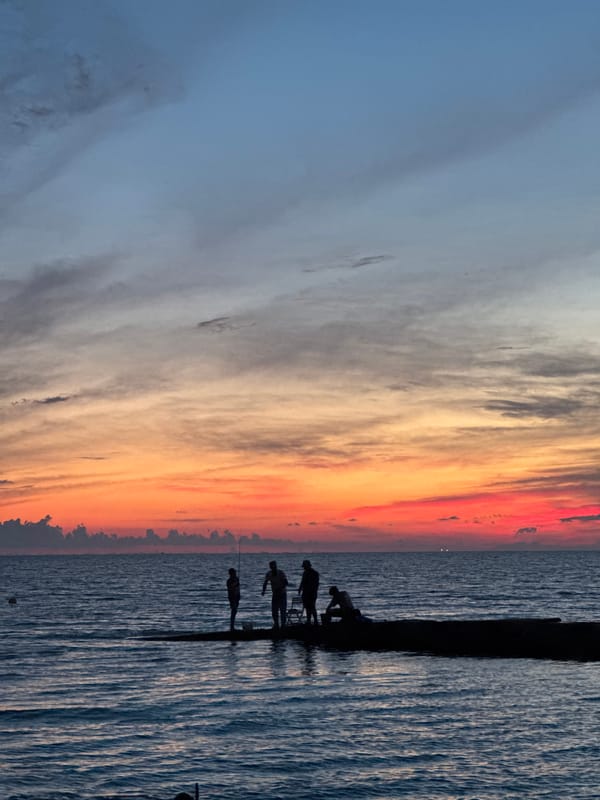 Evening waterfront gathering in Sochi with music, vendors, and sunset views