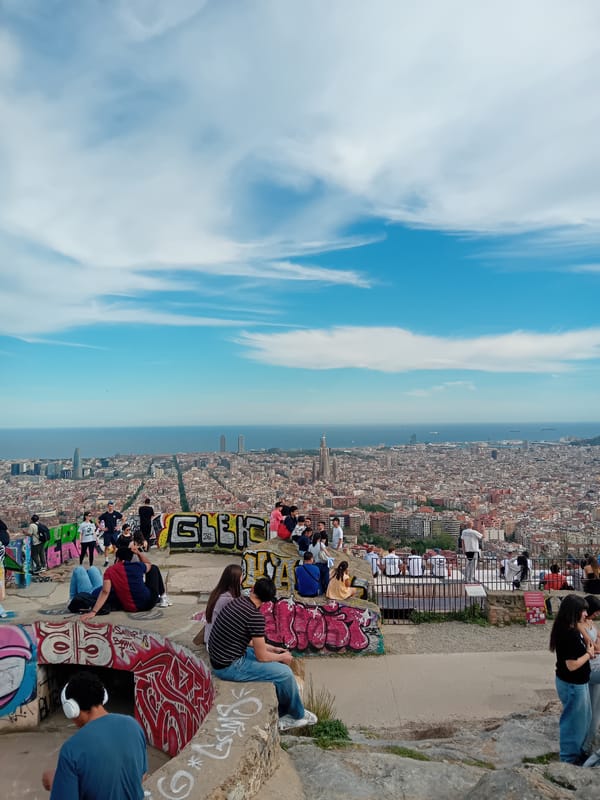 People gather on Barcelona overlook ledge facing Mediterranean Sea