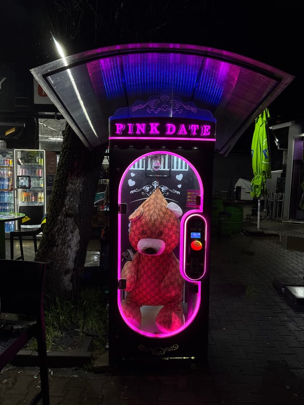 Neon-lit storefronts illuminate Sofia streets during late night hours
