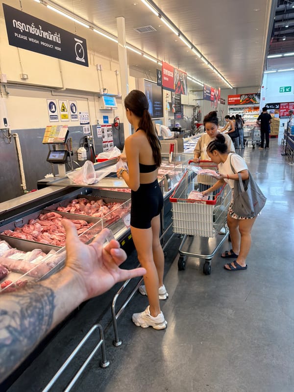 Tattooed shopper buys meat at Bangkok supermarket