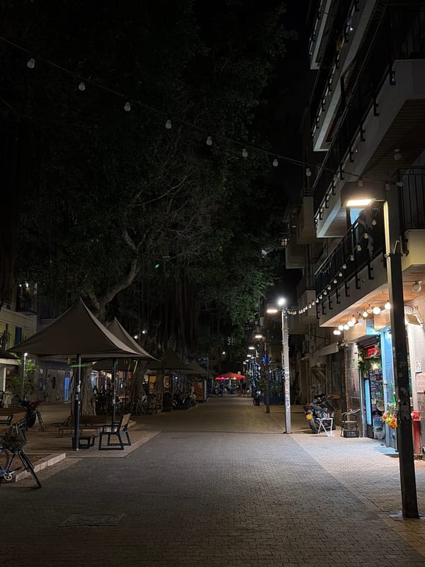 Nighttime street scene captured in Tel Aviv with benches, bicycles
