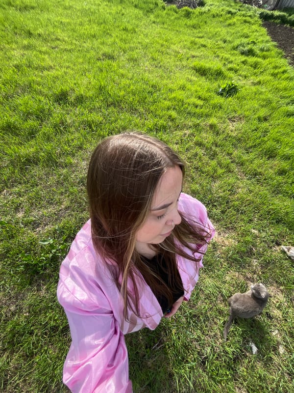 Woman and gray cat photographed on grass in Russia