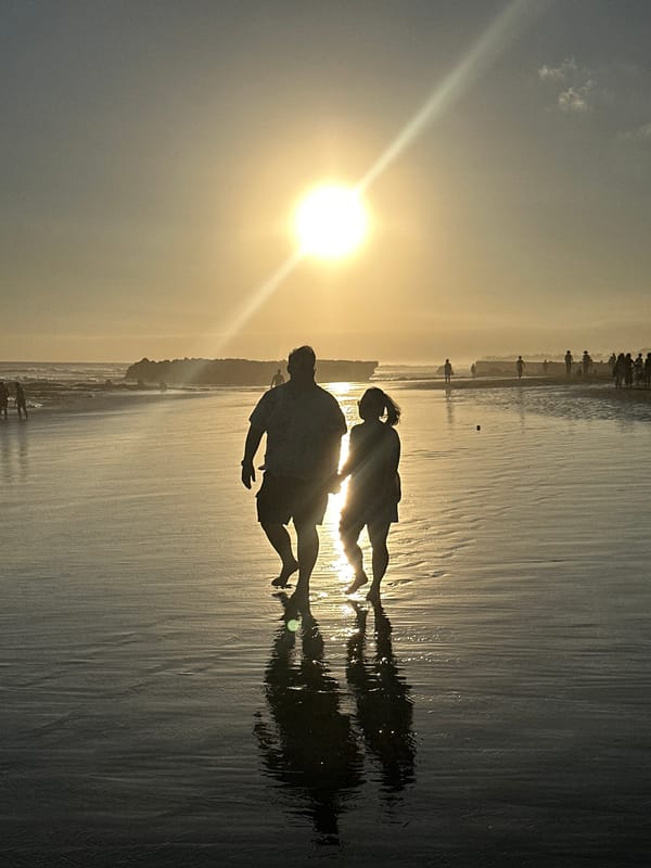 Sunset stroll on the wet sand, North Kuta beach.