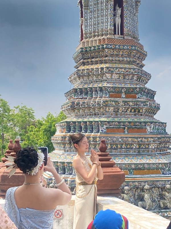 Two women visit Wat Arun temple in Bangkok