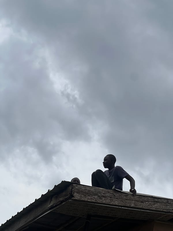 Rooftop repairs on a Jos hillside settlement