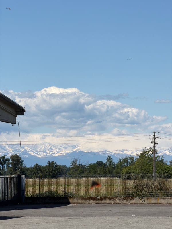 Snow-capped mountains viewed from Gudo Visconti, Italy streets