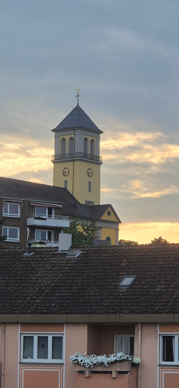 Yellow church tower with twin clock faces, Mainz