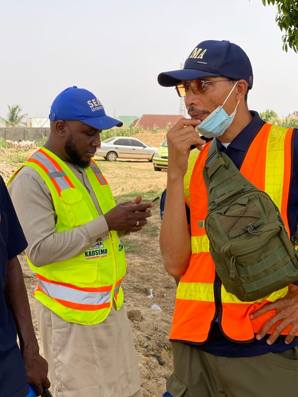 Officials gather in dirt lot in Rigachikun, Nigeria