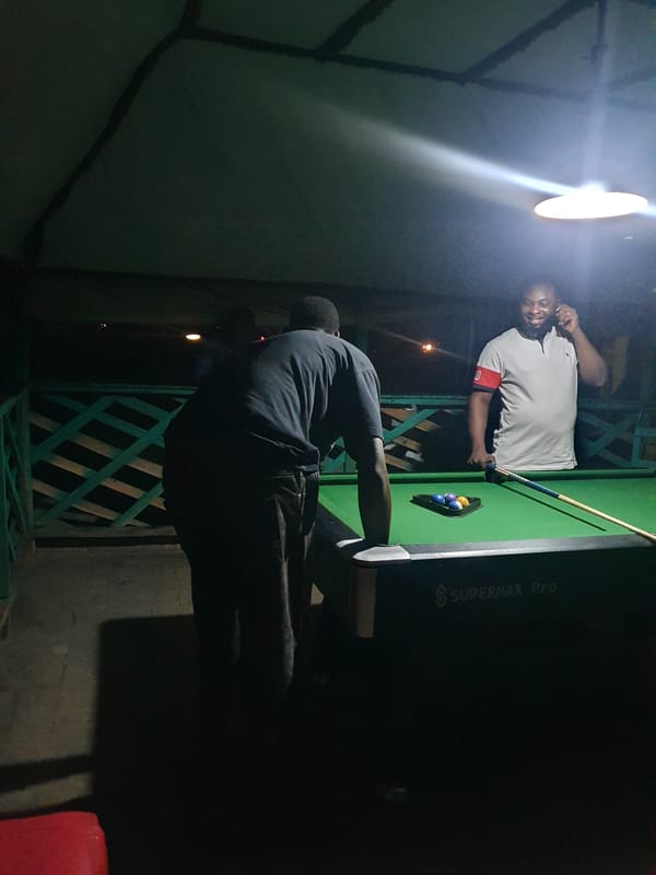 Men play evening pool at outdoor venue in Lokoja