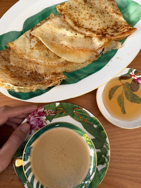 Crepes, coffee, and honey on a wooden breakfast table
