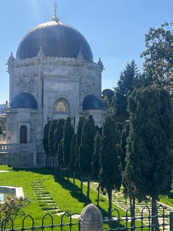 Stone mausoleum with golden dome documented in grassy area