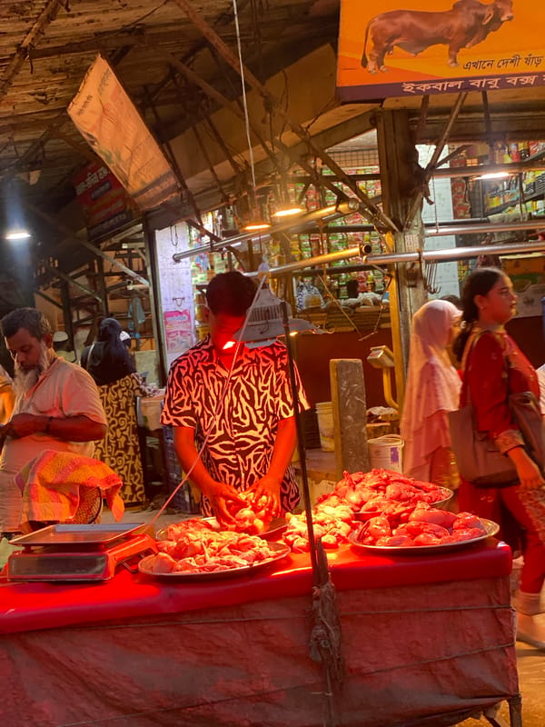 Markets, cafes, and neon-lit streets across a Dhaka neighborhood