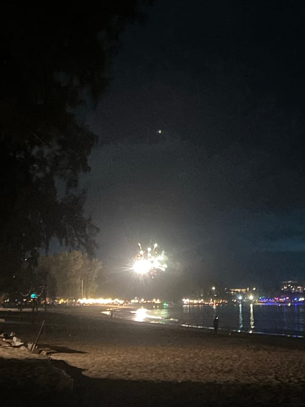 Beachside evening captured: stormy skies, fireworks, candlelit gathering