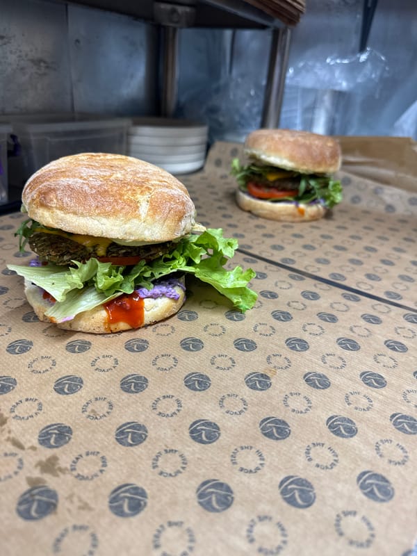 Two prepared sandwiches displayed on cardboard surface