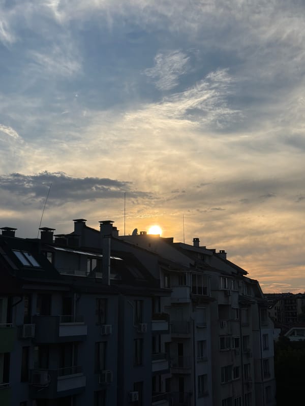 Sofia apartment blocks at golden hour, sun breaking through clouds