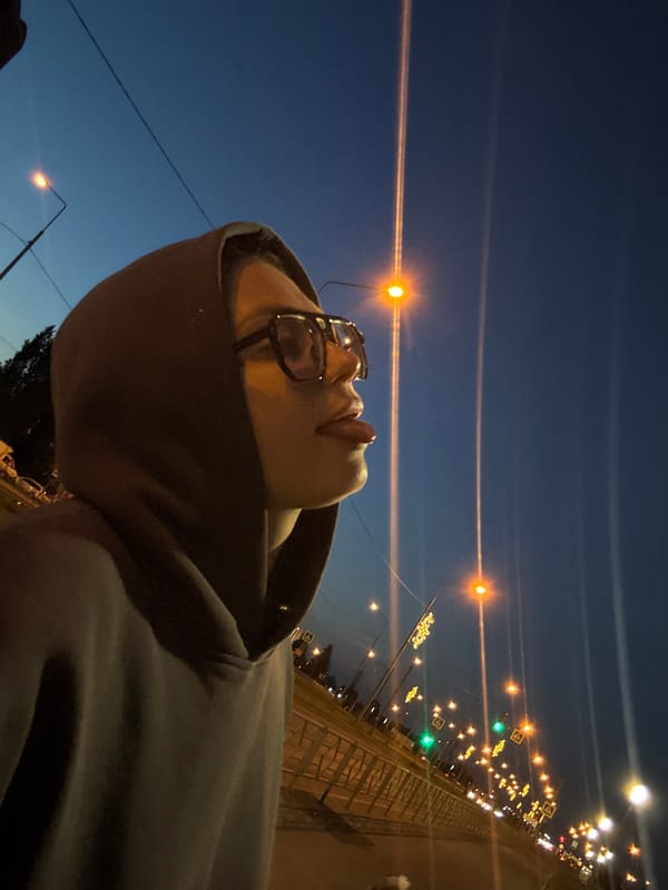 Hooded figure photographed repeatedly during urban twilight walk
