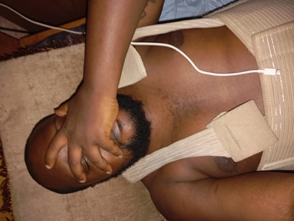 Man rests with chest brace and charging cable