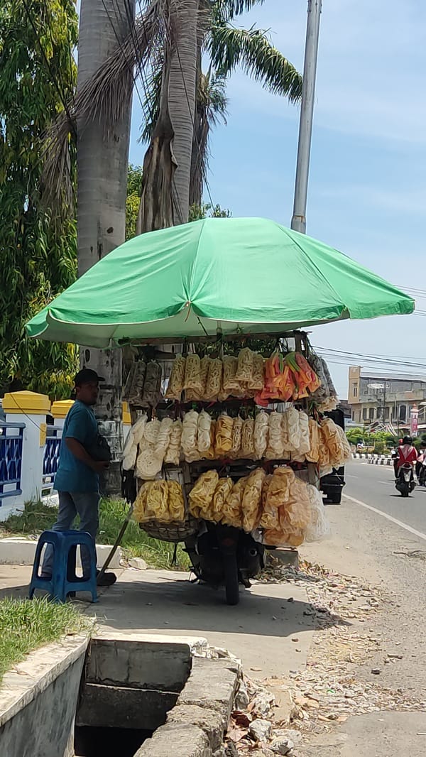 Street vendor operates snack stall in Lhokseumawe morning
