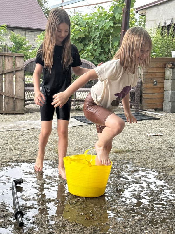 Summer water play around a yellow bucket in Zassovskaya