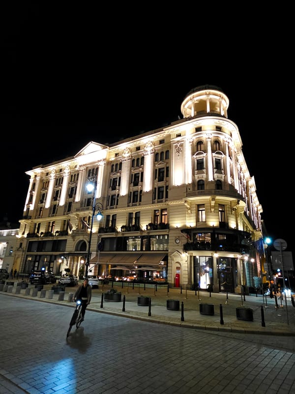 Warsaw's historic center at dusk, classical architecture glowing at night