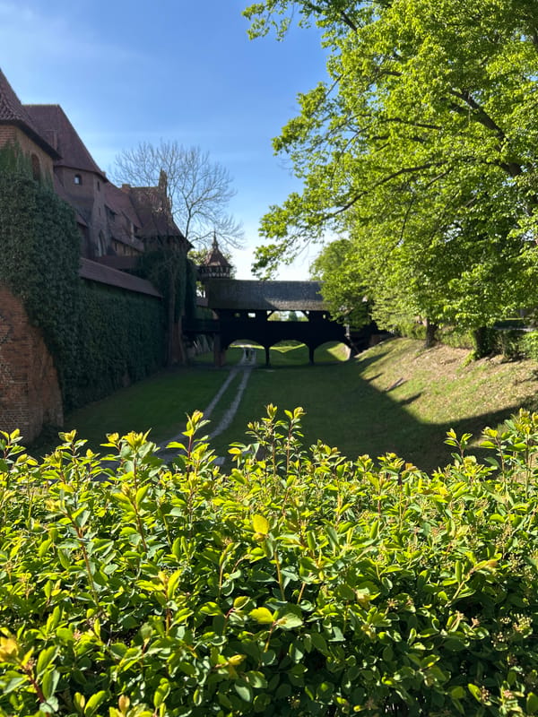 Visitor documents historic Malbork Castle during afternoon tour