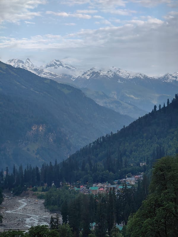Solang Valley's green slopes and snowy peaks on a June afternoon