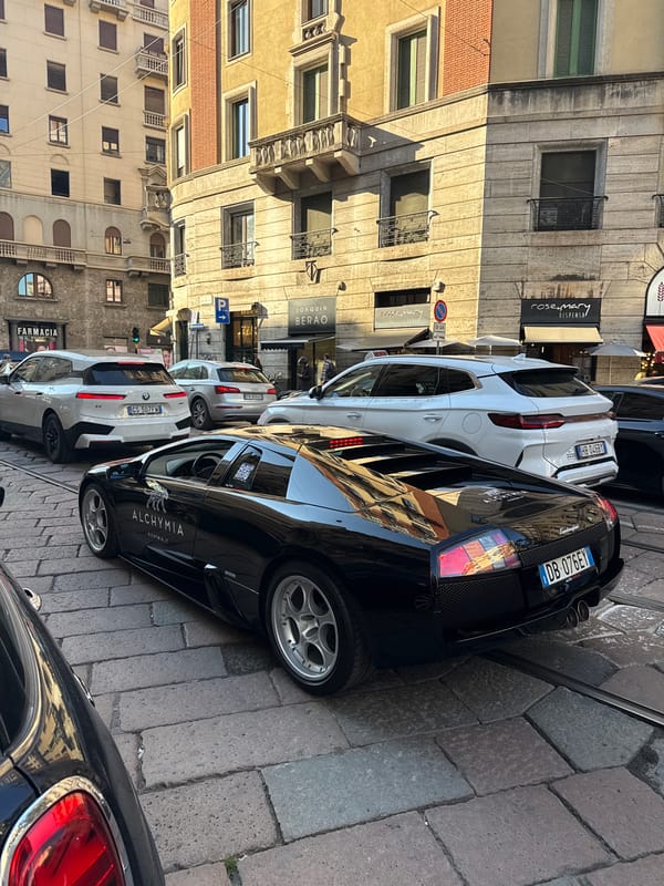 Branded Lamborghini cruises through sunny Milan street scene