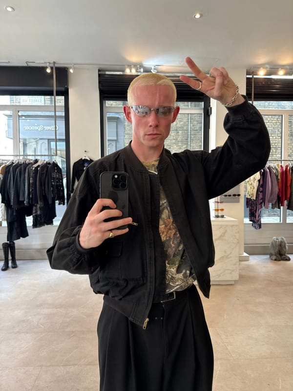 London shopper takes mirror selfie, street scene captured nearby