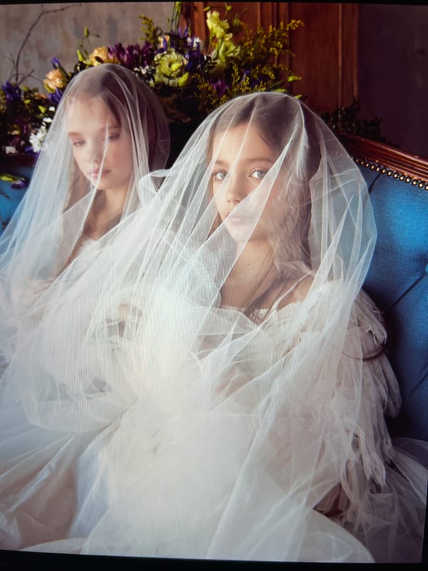 Formal studio portrait session, white dresses on blue velvet sofa