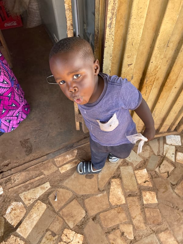 Curious boy looks up at camera in Bukuru