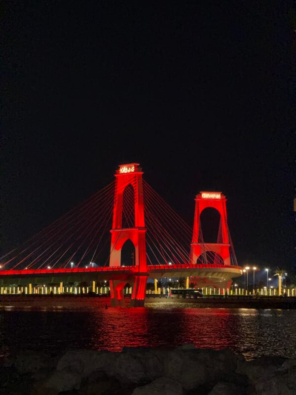 Glowing skyline, red suspension bridge, full moon over the waterfront
