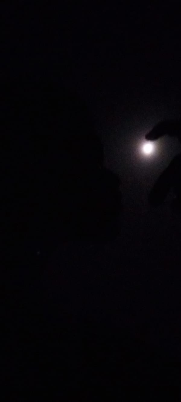 Hand gestures captured against bright lights in Nigerian night scene