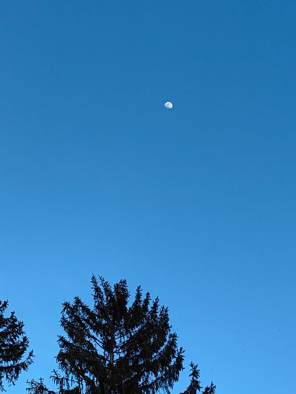 Daytime moon visible over Karlovo Bulgaria mountain landscape