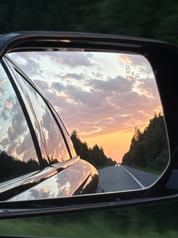Sunset reflected in a side mirror on a Russian road