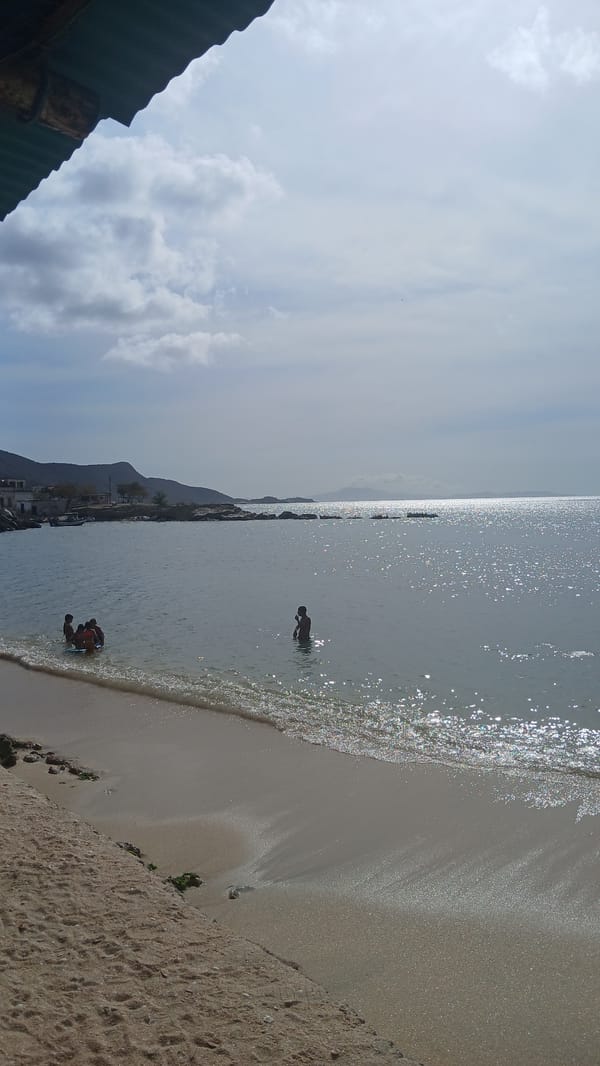 Beachgoers swim and play at Juan Griego harbor