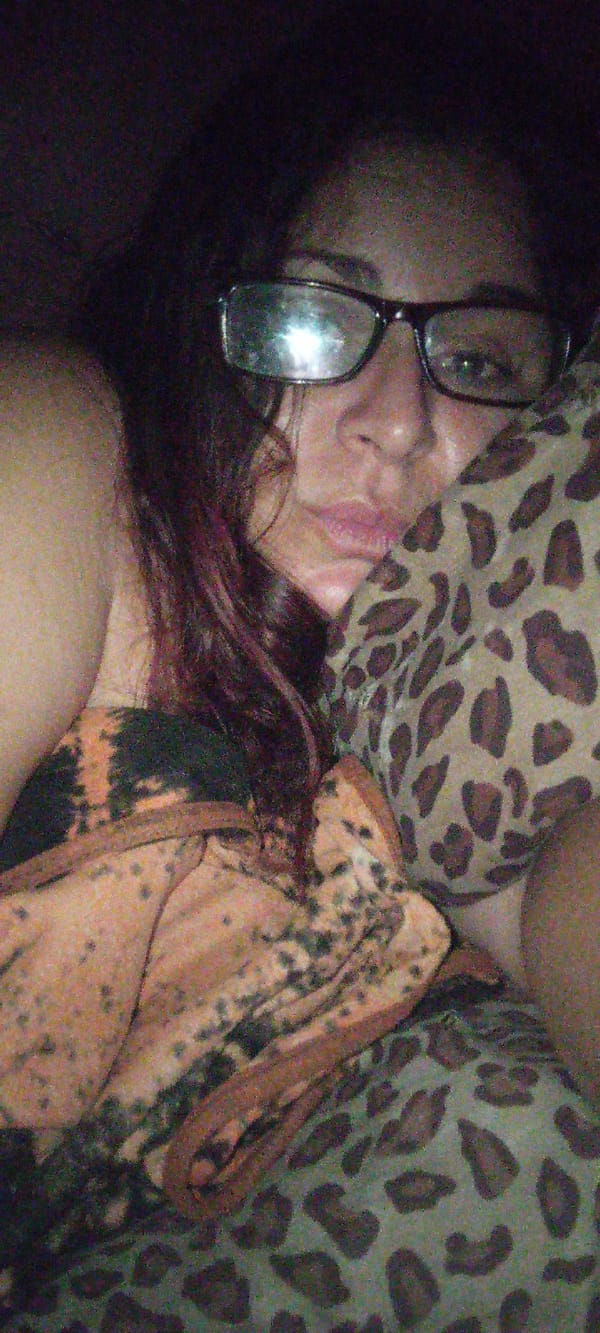 Woman rests on spotted pillow wearing tie-dye clothing