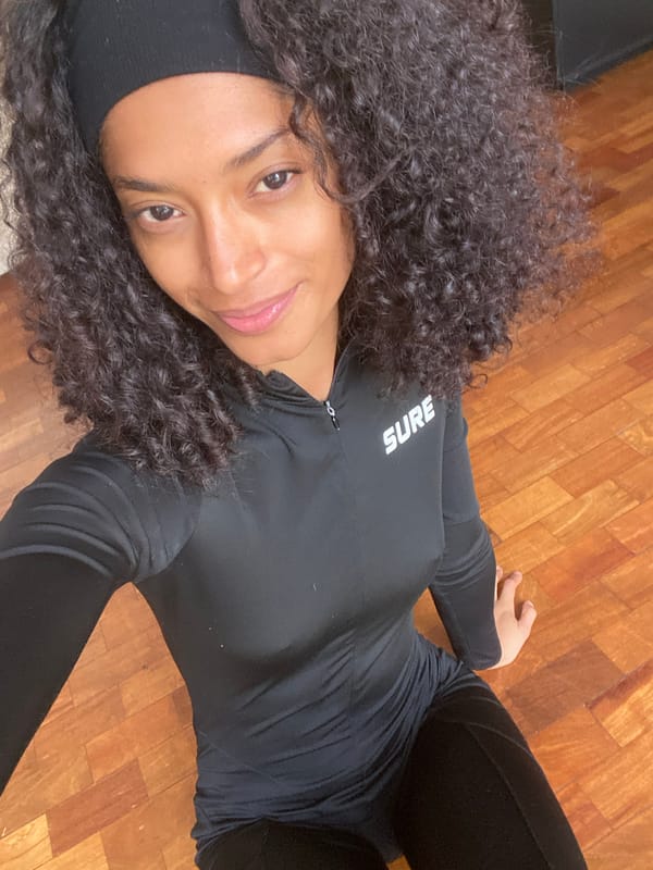 Person in black clothing lying on wooden floor in São Paulo