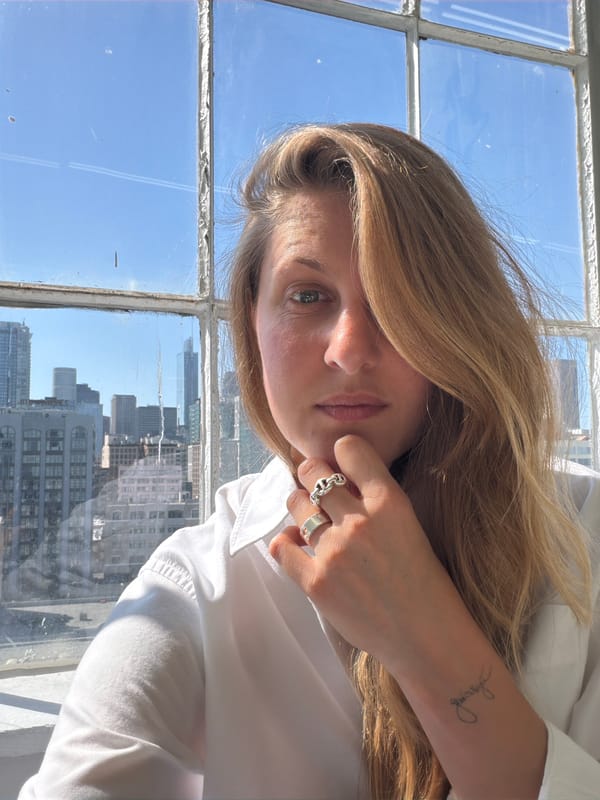 Woman photographs herself indoors with LA cityscape backdrop