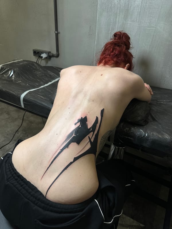Woman gets abstract back tattoo at Moscow parlor