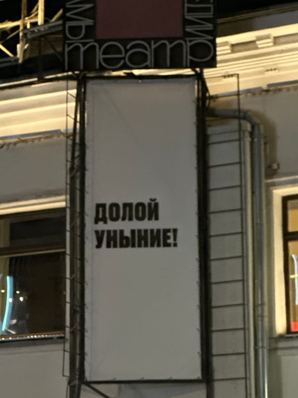 Evening street scene in Moscow features anti-dejection sign, shawarma