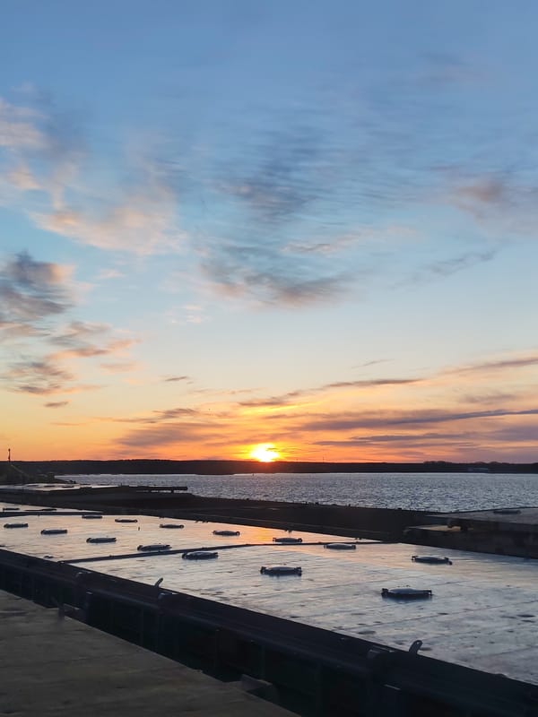 Sunset photographed from barge deck over water body