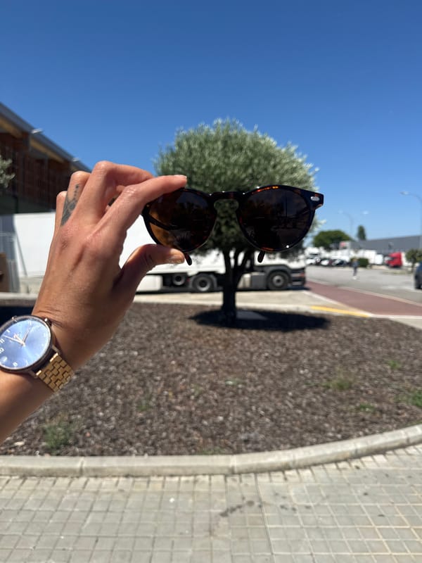 Person tries on sunglasses near racing car in Barcelona