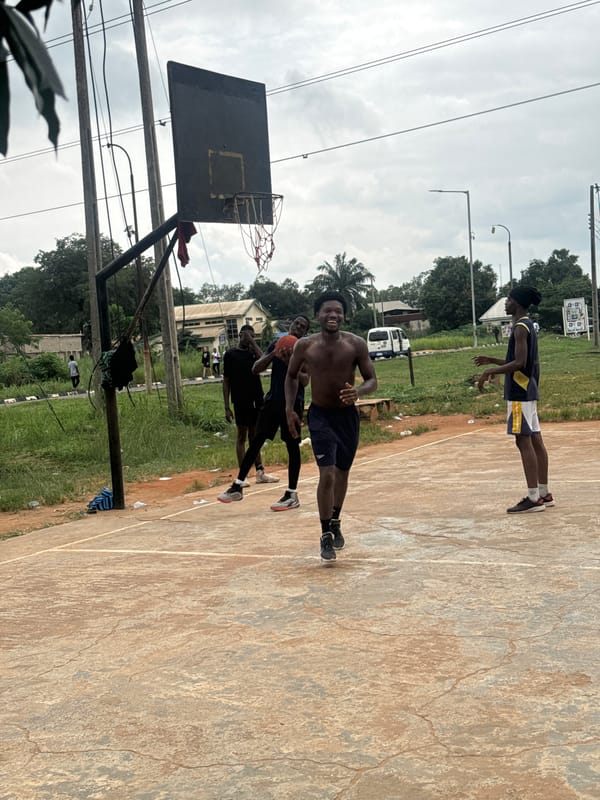 Pickup basketball on a weathered outdoor court in Amansee, Nigeria