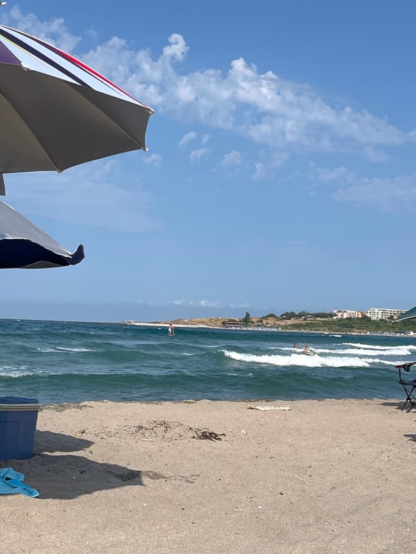 Sunny beach day in Ahtopol with surfing and a kite flying